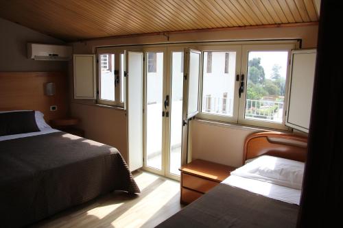 a bedroom with a bed and two windows in a room at B&B MeriGio' in Villapiana