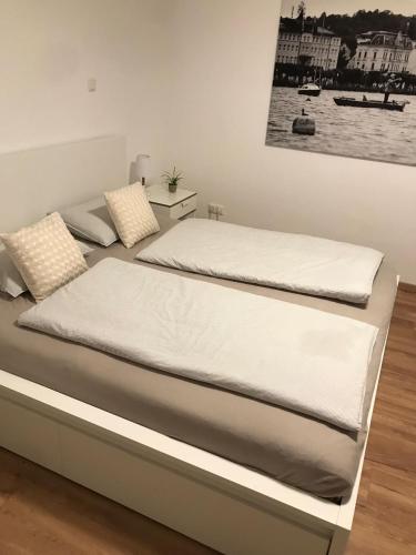two beds in a bedroom with a picture on the wall at Ferienwohnung Gmunden City in Gmunden