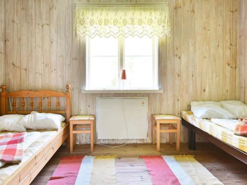 a room with two beds and a window at 8 person holiday home in LÖNSBODA-By Traum in Ubbaboda