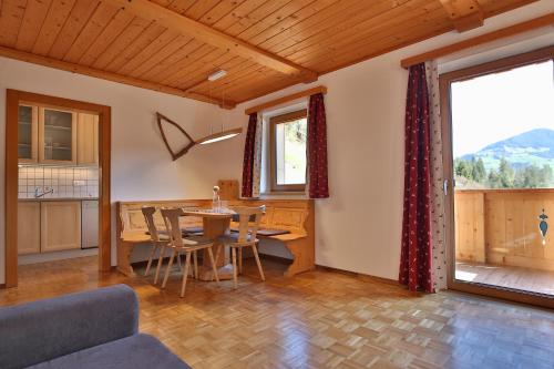 a dining room with a table and chairs and a window at Alpboden in Auffach