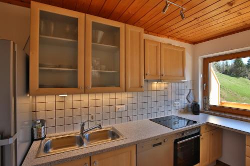 a kitchen with wooden cabinets and a sink and a window at Alpboden in Auffach