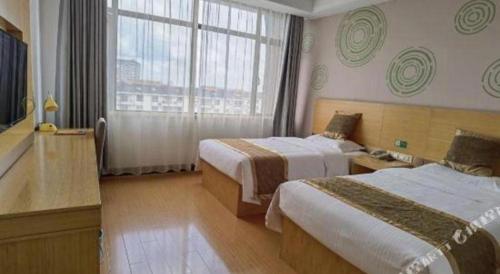 a hotel room with two beds and a window at GreenTree Inn Shanghai Fengxian District Xiaotang Metro Station in Shanghai