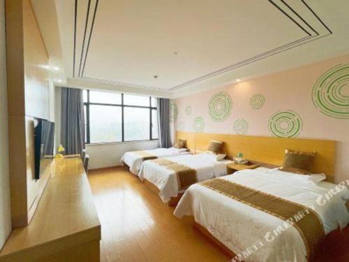 a hotel room with two beds and a flat screen tv at GreenTree Inn Shanghai Fengxian District Xiaotang Metro Station in Shanghai
