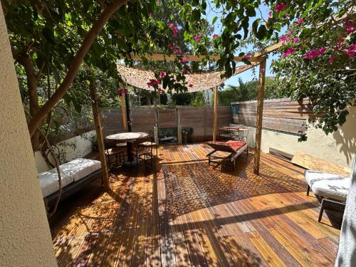 a wooden deck with chairs and tables and a tree at Cascais - Villa at Guincho Beach in Charneca