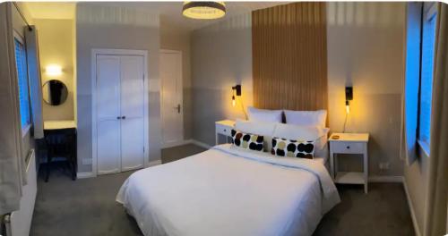 a bedroom with a large white bed with pillows at The Hideaway Carrickfergus in Carrickfergus