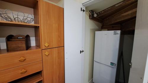 a kitchen with a refrigerator and wooden cabinets at Dom przy Lawendowej Altanie in Kosow