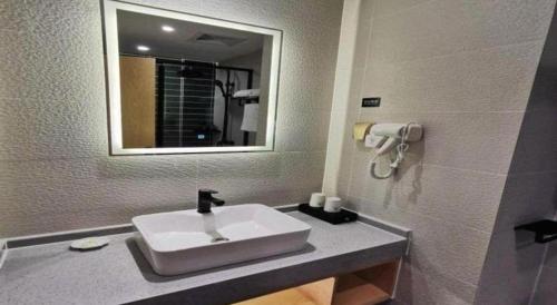 a bathroom with a sink and a mirror at GreenTree Inn Ganzhou Gan County Bus Station in Ganzhou