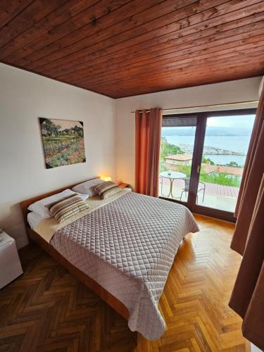 a bedroom with a large bed and a large window at " Rooms Bela" balcony in Ičići