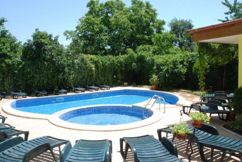 a swimming pool with chairs and a table at Green Hisar Hotel Family in Hisarya