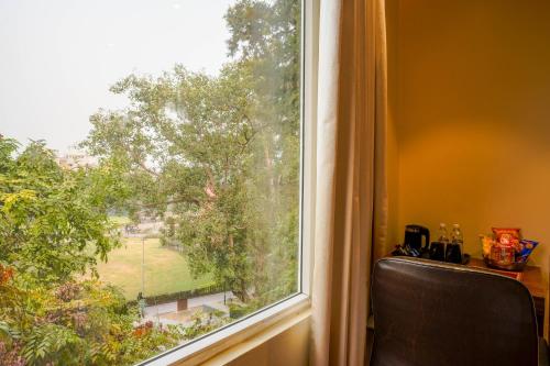 a window with a view of a green yard at Stamps Golden Lagoon by Eight Continents - Opposite to Golden Temple in Amritsar