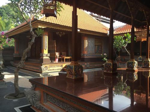 a building with trees in front of it at Gedong Bali Family Homestay in Ubud