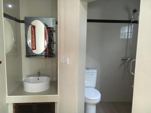 a bathroom with a toilet and a sink and a mirror at Gedong Bali Family Homestay in Ubud