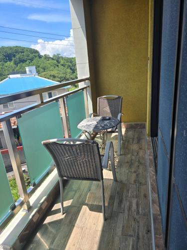 a balcony with two chairs and a table at Cheonjiyeon Hotel in Seogwipo