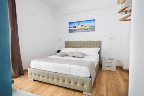 a bedroom with a large bed with white sheets at Appartamenti Trapani In in Trapani