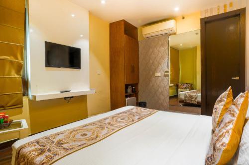 a bedroom with a bed with a tv on the wall at Stamps Golden Lagoon by Eight Continents - Opposite to Golden Temple in Amritsar