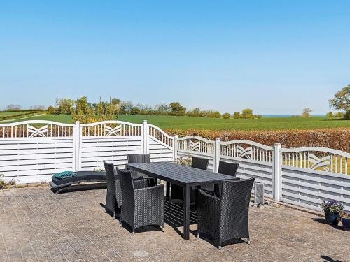 a black table and chairs next to a white fence at 4 person holiday home in Tranekær in Tranekær