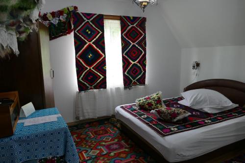 a bedroom with a bed and a window with curtains at Pensiunea Irina Maramureș in Deseşti