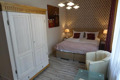 a small bedroom with a bed and a chair at Hotel Villa Konstanz in Berlin