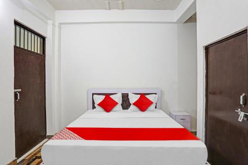 a bedroom with a bed with red pillows at Hotel O NIKKU HOTEL in Noida