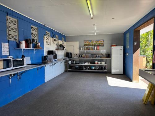 a kitchen with blue walls and a white refrigerator at Bushchooks Travellers Village in Bororen