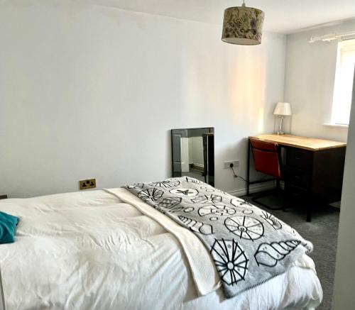 a bedroom with a bed with a dresser and a desk at South Wales Coastal Retreat in Llanelli