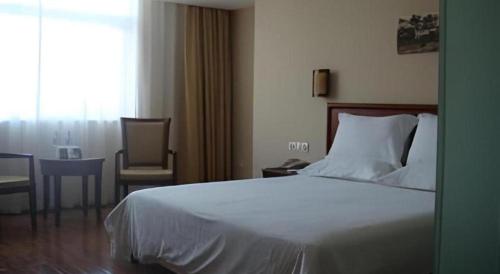 a bedroom with a bed and a table and a window at GreenTree Inn Nanning Langdong Hotel in Nanning