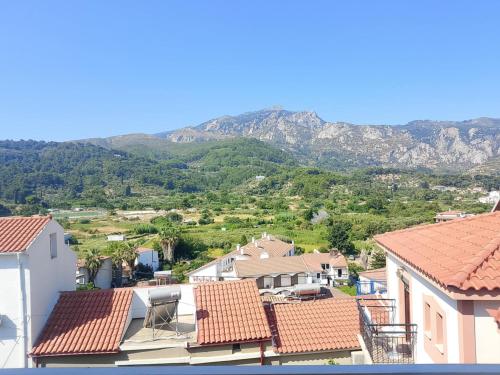 a view of a town with mountains in the background at Green Hill Studios & Apartments in Kokkari