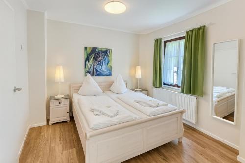 a bedroom with a large white bed and a window at Landhaus Fillerberg in Wildeshausen