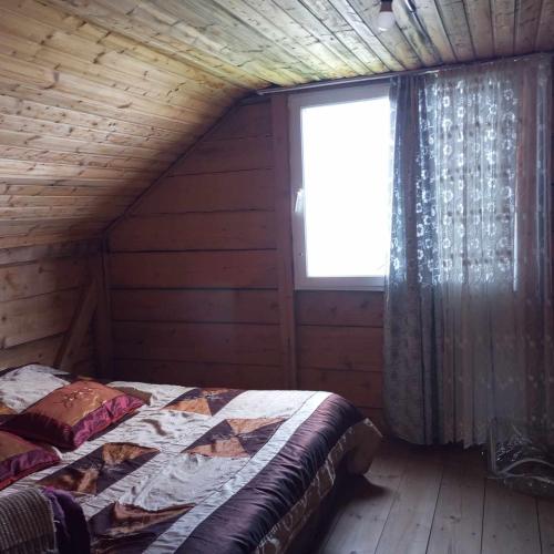 a bedroom with a bed in a log cabin at Gomismta Panorama in Gomi