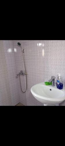 a white bathroom with a sink and a shower at Gomismta Panorama in Gomi