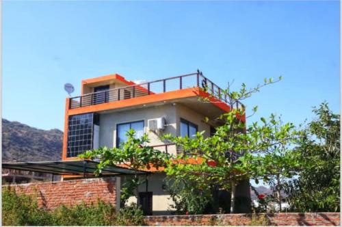 a house with a balcony on top of it at Olivstays by Offbeat in Udaipur