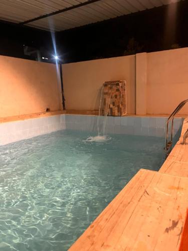 a swimming pool with a water fountain in it at Olivstays by Offbeat in Udaipur