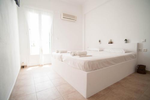 a white bedroom with a large white bed at Giosifaki in Vari