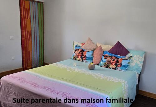 a bedroom with a bed with colorful pillows at Hei Hei in Papetoai