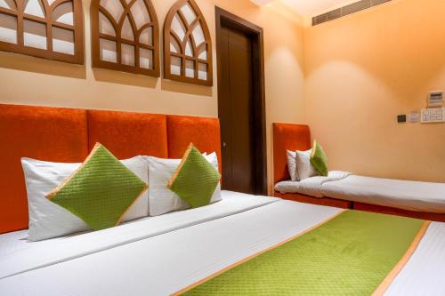 a bedroom with two beds with green and white pillows at Stamps Golden Lagoon by Eight Continents - Opposite to Golden Temple in Amritsar