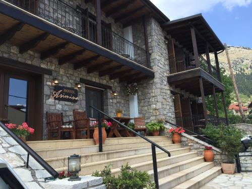 a building with stairs and chairs in front of it at Asimina Guesthouse, Eptalofos Parnassos in Eptalofos