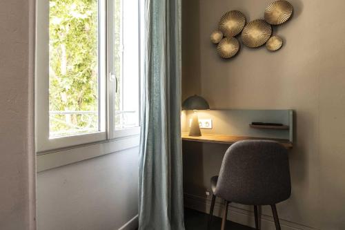 a room with a desk with a chair and a window at Hotel Burrhus in Vaison-la-Romaine
