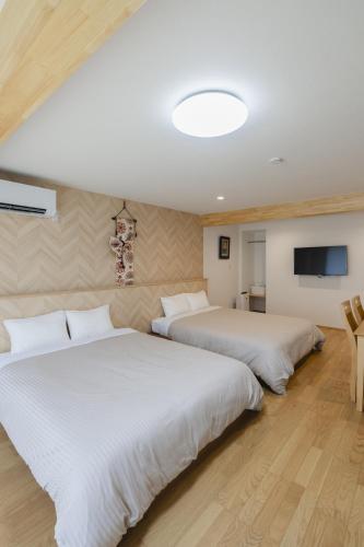 a bedroom with two beds and a flat screen tv at 楚々Soso in Miyazu