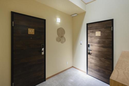 a corridor with two doors in a room at 楚々Soso in Miyazu