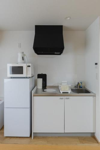 a kitchen with a white refrigerator and a microwave at 楚々Soso in Miyazu