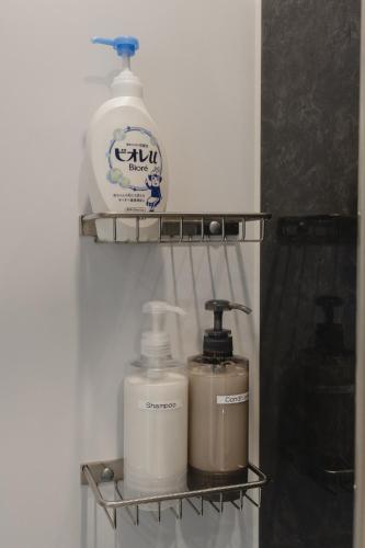 a shelf with two bottles of soap and a detergent at 楚々Soso in Miyazu