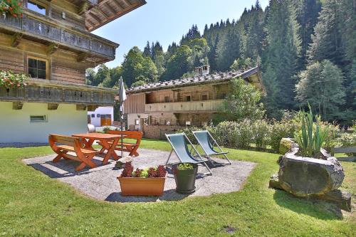 a backyard with a table and chairs and a house at Alpboden in Auffach