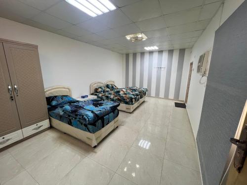 a room with three beds in a room at Maeen Rest House in Ma‘mad