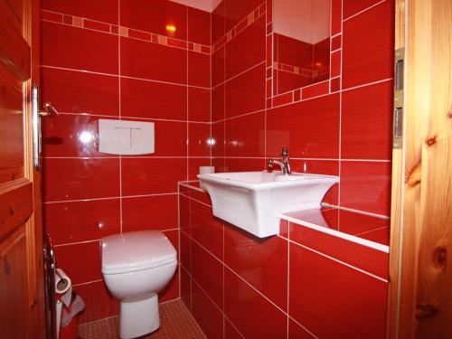 a red tiled bathroom with a toilet and a sink at Gutshaus in Gressow mit Teich in Gressow