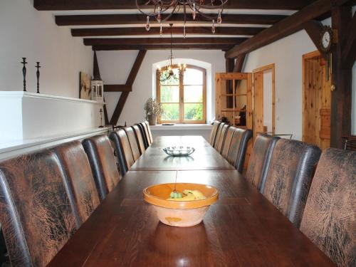 a dining room with a long table with leather chairs at Gutshaus in Gressow mit Teich in Gressow