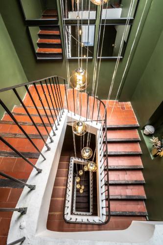 a spiral staircase with a chandelier at Hotel Burrhus in Vaison-la-Romaine