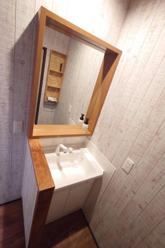 a bathroom with a sink and a mirror at 日向サーフキャンプ107 in Hyuga