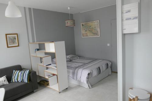 a small bedroom with a bed and a couch at Studio proche gare St Jean in Bordeaux