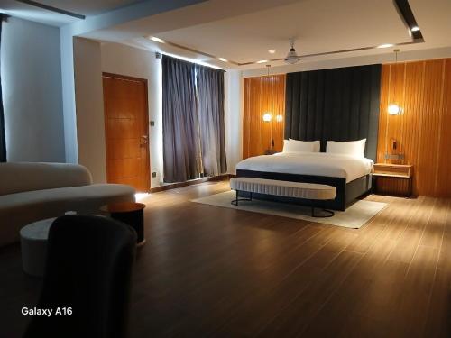 a bedroom with a bed and a couch and a chair at IFQ Premier Skardu in Skardu
