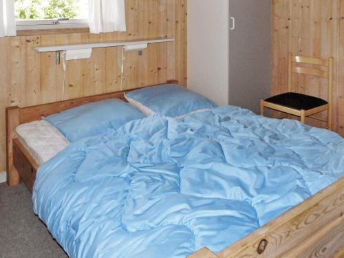 a large bed with blue sheets in a bedroom at Cozy Retreat with Spa - By Traum Ferienwohnungen in Sarup